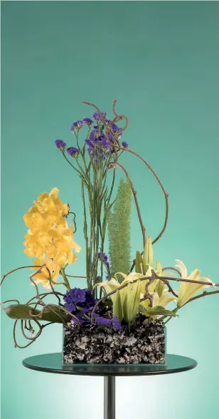  ??  ?? [2]
A artista floral Tania Santos, de São Paulo, SP, usou violeta, estatice, lírio, orquídea Cymbidium, aspargo, base de vidro com líquen e ramos de kiwi nesta composição