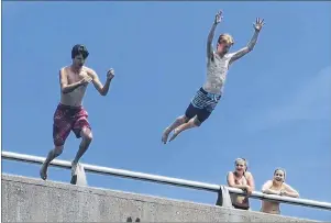  ?? DAVID JALA/CAPE BRETON POST ?? Glace Bay teens Nolan Parsons, left, and Evan McNeil soar off Albert Bridge and into the Mira River on Tuesday afternoon as a group of girls watch from above. The boys said there’s nothing better than a dip in the river when the weather is as hot and...