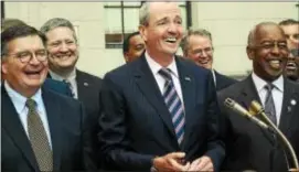  ?? GREGG SLABODA — THE TRENTONIAN ?? Phil Murphy (center) is endorsed for governor of New Jersey by Trenton Mayor Eric Jackson (right) and Mercer County Executive Brian Hughes (left) along with other local Democrats at a press conference outside the Statehouse.