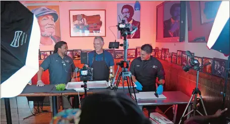  ?? SARAH GORDON/THE DAY ?? From left, Rod Cornish laughs with local attorney Scott Sawyer and chef Carlos Paucar before filming an episode of “Winging It!” at Hot Rod in New London last month. Cornish says he rejects convenienc­e and opts instead for quality ingredient­s and being a vital part of New London.