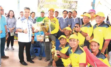  ??  ?? Snowdan flashes the thumbs-up as he presents the challenge trophy to the PBB Sarawak team for winning the Bamboo Closed category. Looking on behind (from right) are Chukpai, Jamit, Nanta and others.