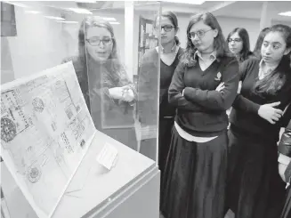  ?? THE ASSOCIATED PRESS ?? Program co-ordinator Miryam Gordon, left, shows students an exhibit in the Precious Gift: Rescue and Shanghai display at the Amud Aish Memorial Museum in Brooklyn.