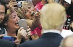  ?? JOHN LOCHER / THE ASSOCIATED PRESS ?? Supporters react while meeting Republican presidenti­al candidate Donald Trump.