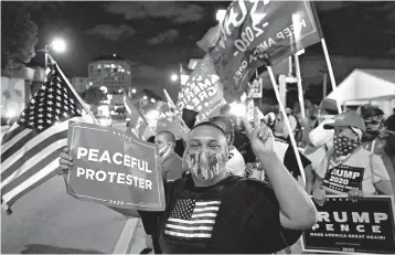  ?? WILFREDO LEE/AP ?? Supporters of President Trump chant and wave flags during Election Night, in the Little Havana neighborho­od of Miami.