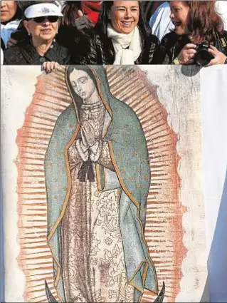  ?? CNS ?? Unas mujeres con un tapiz de la Virgen de Guadalupe, en Morelia (Mexico) en 2016