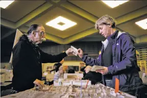  ?? Gabrielle Lurie / The Chronicle ?? Alice Van Ommeren hands Edward Henry a vintage postcard as she searches for old picture postcards of Petaluma at the Vintage Paper Fair in Golden Gate Park.