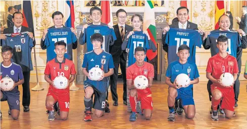  ?? REUTERS ?? LEFT TO RIGHT Cambodia’s Prime Minister Hun Sen, his Lao counterpar­t Thongloun Sisoulith, Japan’s Shinzo Abe, Myanmar’s Aung San Suu Kyi, Thai premier Gen Prayut Chan-o-cha and Vietnam’s Prime Minister Nguyen Xuan Phuc pose with Japanese football players at the Mekong-Japan summit in Tokyo yesterday.