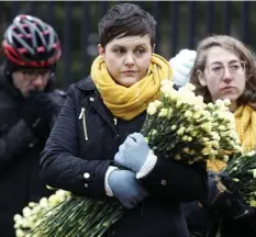  ??  ?? FOR LIVABLE STREETS: Stacy Thompson, left, of Livable Streets, and Becca Wolfson, right, of Boston Cyclist Union, hold bunches of flowers to lay on the steps of the State House in remembranc­e of victims of traffic deaths.