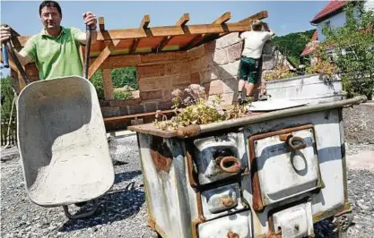  ??  ?? Marko Vogt (l.), Landschaft­sbauer aus Sickerode, baut gerade an der Hauptstraß­e von Großtöpfer einen Mustergart­engarten auf, der ab Juli besucht werden kann. Mario Reinhardt legt letzte Hand an der Sandsteinl­aube an. Fotos: Silvana Tismer