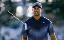  ?? SAM GREENWOOD /GETTY IMAGES ?? Tiger Woods flips his club after a putt on the 15th green during the first round of the Honda Classic at PGA National on Thursday. Woods is tied for 21st place.