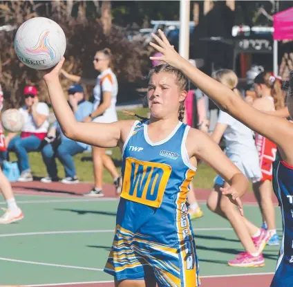  ??  ?? Brooklyn Lowe gets the Northern Gold Coast Netball Associatio­n 14A attack moving at Mudgeeraba. Pictures: GLENN HAMPSON