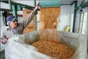  ?? ELIJAH NOUVELAGE / REUTERS ?? A worker fills a shipping container with almonds at Capay Canyon Ranch in Esparto, California, in April.