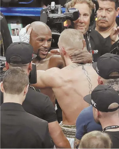  ?? AP PHOTO ?? MUTUAL RESPECT: Floyd Mayweather Jr. (left) embraces Conor McGregor after their fight Saturday night in Las Vegas. Mayweather won on a 10th-round technical knockout.