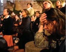  ?? PHOTOS: GETTY IMAGES ?? Devastated: Faithful pray as they watch Notre-Dame Cathedral destroyed by fire.