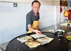  ??  ?? Chang loves roti canai so much that he learnt to make it from a friend before opening his own shop. — CHING YEE SING