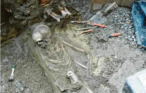  ?? Fotos: Silvio Wyszengrad ?? Bei einer Baustelle am Kesselmark­t in der Augsburger Innenstadt graben Archäologe­n die Knochen von Verstorben­en aus dem Mittelalte­r aus.