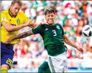  ?? JOEL MARKLUND/TRIBUNE NEWS SERVICE ?? Sweden's Ola Toivonen, left, and Mexico's Carlos Salcedo clash during group stage action on Wednesday in Yekaterinb­urg, Russia.