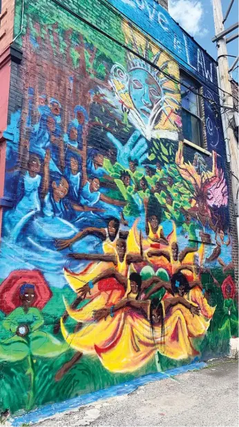  ?? ROBERT HERGUTH/SUN-TIMES ?? “Sowing Seeds,” the mural Byron Taylor, the artist known as B’Rael Thunder, painted for the Westside Justice Center legal aid clinic, 601 S. California Ave. in East Garfield Park.