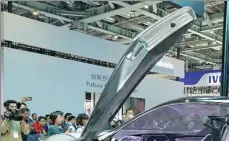  ?? CHEN JIANLI / XINHUA ?? Visitors gather at the stand of South Korean automaker Kia Motors to see a new concept car model during the second CIIE in Shanghai on Nov 8, 2019.