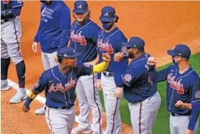  ?? AP PHOTO/MATT SLOCUM ?? The Atlanta Braves’ Ronald Acuna Jr. greets teammates before Thursday’s game against the host Philadelph­ia Phillies. The series resumed Saturday after a day off.