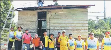  ??  ?? Paulus (sixth left) and other Saberkas Batu Danau members in a photo call in front of the house they repaired.