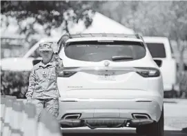  ?? DAVID SANTIAGO dsantiago@miamiheral­d.com ?? A Florida Army National Guard troop directs cars to the COVID-19 drive-thru testing center at Marlins Park on Tuesday in Miami. The site will open today for testing of people 65 and over with symptoms of COVID-19.