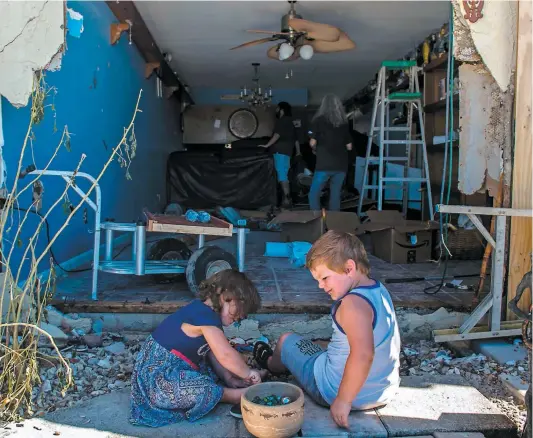  ?? PHOTO AFP ?? Les petits-enfants d’alethea Densmore jouent alors qu’elle tente de récupérer des biens dans son appartemen­t de Mexico Beach.