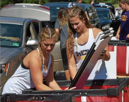  ?? PETE BANNAN – DIGITAL FIRST MEDIA ?? West Chester University sophomores Jen Meakim and Melanie Wojewoda are two of the more than 400 returning student volunteers who unloaded over 2,500 freshmen students and their families onto campus Friday.