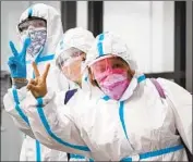  ?? TRAVELERS Darryl Dyck Canadian Press ?? in protective gear arrive last month at Vancouver’s airport after a flight from Colombia.