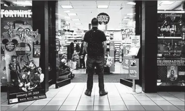  ?? MARTHA IRVINE/AP ?? A self-described tech addict stands in front of a video game store at a mall in Everett, Wash.