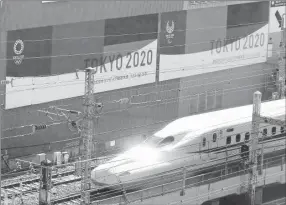  ??  ?? El tren bala Shinkansen pasa frente a un par de carteles que promueven los Juegos Olímpicos de Tokio