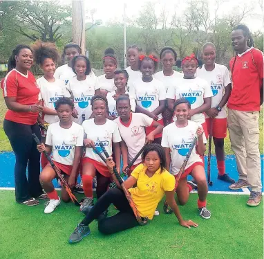  ??  ?? The hockey champions at the JN Hockey Field with their coaches Kerieon Grant (left) and George McGlashan (right).