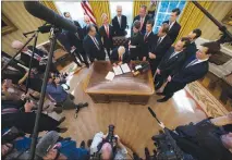  ?? DOUG MILLS / THE NEW YORK TIMES ?? President Donald Trump signs an executive order to establish regulatory reform officers and task forces within federal agencies as part of his push to slash federal government regulation­s, on Feb. 24 in the Oval Office. Trump’s campaign to cut...