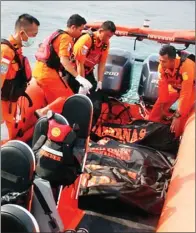  ?? CECEP MULYANA/BATAM POS ?? KERJA KERAS: Petugas Basarnas mengevakua­si korban meninggal akibat tenggelamn­ya kapal pengangkut TKI ilegal di perairan Batam.