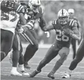  ?? MICHAEL CONROY/AP ?? The Colts’ Jonathan Taylor, middle, runs during the second half against the Jets Thursday in Indianapol­is.