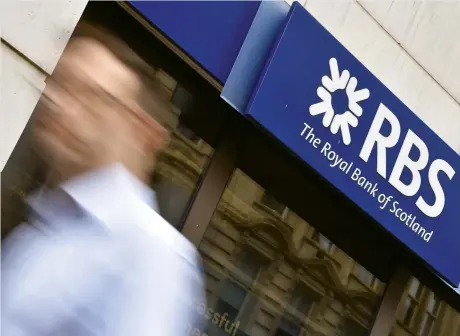  ??  ?? A man walks past a branch of The Royal Bank of Scotland in central London. As more people bank online, many lenders are closing their high street branches. (Reuters)