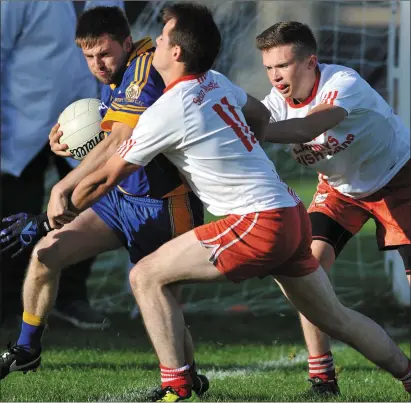  ??  ?? Kevin Collier,Wolfe Tones comes under pressure from Brendan McDonnell,John Mitchel’s as he attempts to clear his lines. Picture: Ken Finegan