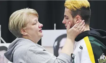  ?? JONATHAN HAYWARD/THE CANADIAN PRESS ?? Humboldt Broncos player Nick Shumlanski, who was released from hospital earlier Sunday, is comforted during the vigil.