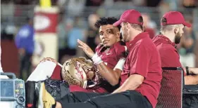  ?? MORGAN TENCZA/USA TODAY SPORTS ?? Florida State quarterbac­k Jordan Travis, back, waves to fans while being carted off after an injury against North Alabama during the first quarter at Doak S. Campbell Stadium.