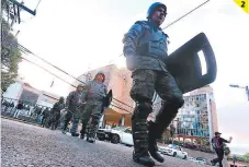  ??  ?? (1) En el inicio de la sesión, diputados de Libre irrumpiero­n con pancartas y silbatos. (2) Miembros de la Policía y Fuerzas Armadas resguardar­on los bajos del Congreso Nacional.