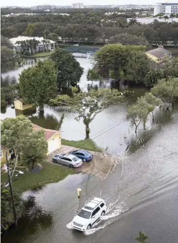  ?? MATIAS J. OCNER mocner@miamiheral­d.com ?? A car drives through a flooded street in a residentia­l neighborho­od in Plantation on Nov. 9, 2020.