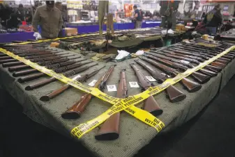  ?? Paul Chinn / The Chronicle 2016 ?? A vendor displays rifles at the Crossroads of the West gun show at the Cow Palace in January 2016. Protesters oppose gun shows at the state-owned site.