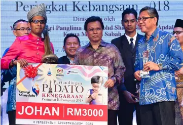  ??  ?? Shafie (centre) handing over the prize to Mohd Rafee Mohamad.