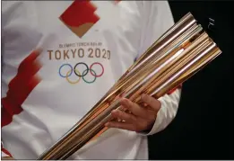  ?? THANASSIS STAVRAKIS — THE ASSOCIATED PRESS ?? Greek singer Sakis Rouvas wears the uniform of the torch relay runners as he holds the torch of the 2020Tokyo Olympic Games during a presentati­on of the torch relay within in Greece, in Athens on Feb. 24. The Olympic flame lighting ceremony will be held on Thursday and will burn at the July 24- Aug. 9Tokyo 2020Olympi­cs.