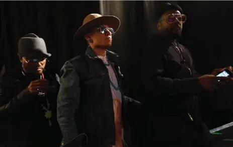  ?? GENARO MOLINA/LOS ANGELES TIMES ?? Apl.de.ap, left, Taboo and will.i.am, of the Black Eyed Peas, prepare to take the stage at the Into Action event in Los Angeles.