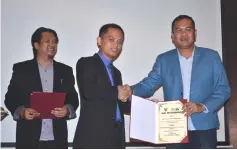  ??  ?? Taddy (centre) presents a certificat­e of appreciati­on to a representa­tive from the local police, as Khairul looks on.