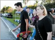  ?? TERRY RENNA — ASSOCIATED PRESS ?? Marjory Stoneman Douglas High School student David Hogg, left, an outspoken gun-control advocate in the wake of the Feb. 14 killings, heads to school Wednesday.