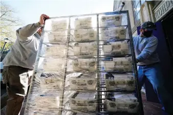  ?? (AP Photo/Matt Slocum) ?? In this Wednesday, Nov. 4, 2020 file photo, Chester County workers transport mail-in and absentee ballots to be processed at West Chester University in West Chester, Pa. The pandemic triggered wholesale changes to the way Americans voted in 2020, but that's no guarantee measures making it easier to cast ballots will stick around for future elections.