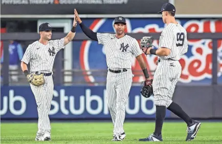  ?? WENDELL CRUZ/USA TODAY SPORTS ?? Andrew Benintendi, left, acquired in a trade Wednesday, celebrates a win over his former team, the Royals, with teammates Aaron Hicks and Aaron Judge.