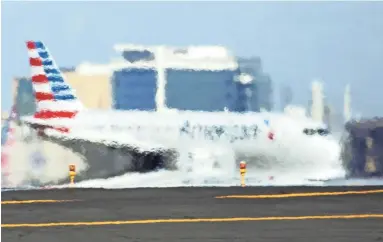  ?? ROB SCHUMACHER/THE REPUBLIC ?? An American Airlines jetliner is seen though heat waves rising from the tarmac Friday at Sky Harbor Internatio­nal Airport.